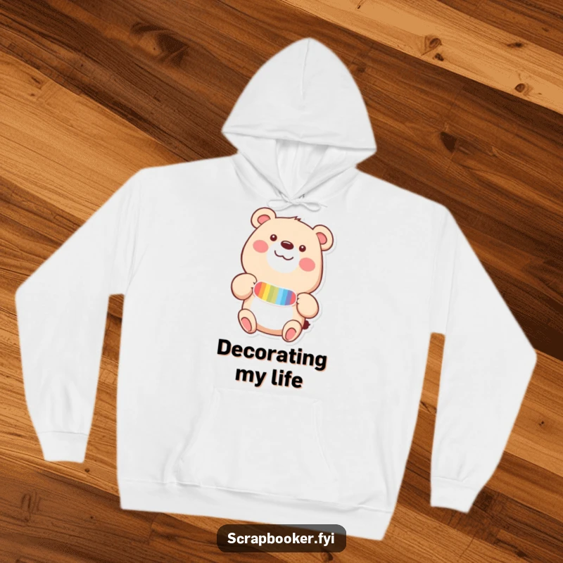 Funny hoodie with a happy bear adding a colorful sticker to a page with delight, providing cozy comfort and cheer.
