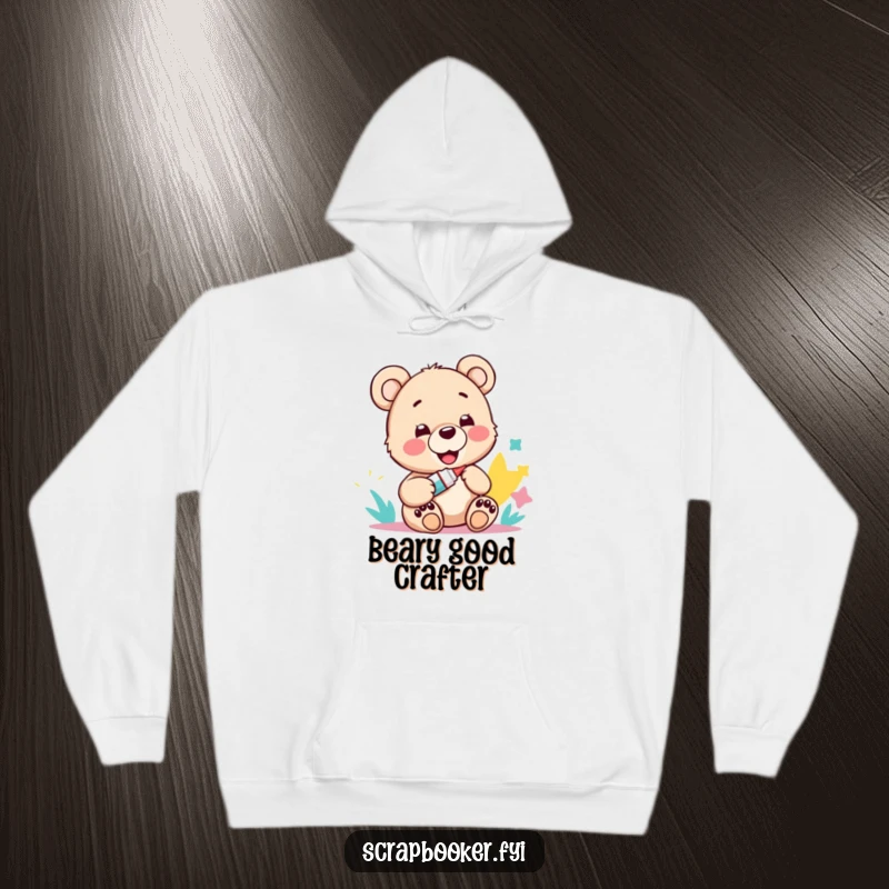 Funny hoodie featuring a happy bear cub with a glue stick and paper art, ideal for cozy crafting.