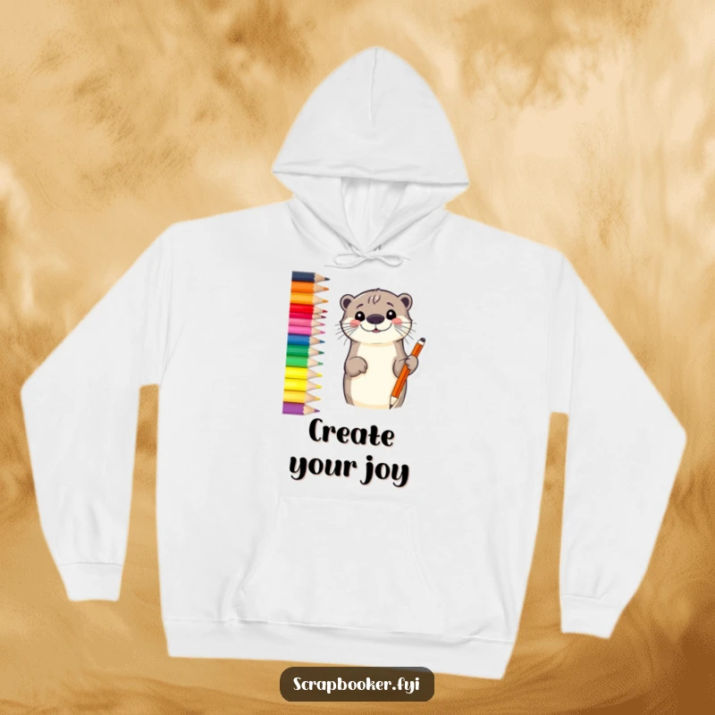 Funny otter hoodie featuring a smiling otter sketching a border with a vibrant colored pencil, embodying cozy creativity.